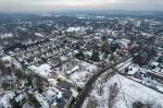 Dzień, zima, śnieg na ziemi, panorama miasta z drona. Przeważa zabudowa kilkukondygnacyjna.